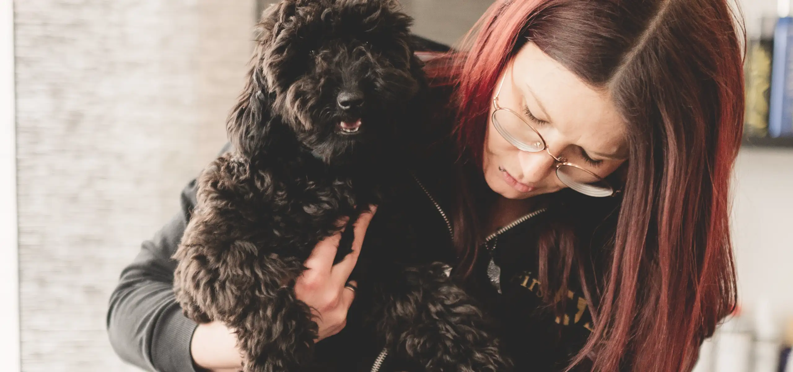 Nicole Zöscher kümmert sich liebevoll um die Pfoten eines Kundenhundes bei First Dog in Gratkorn